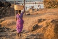 GOA, INDIA - MARCH 4: Woman in saris with basket on her head walks by Vagator beach on March 4, 2017 in Goa, India