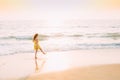 Goa, India. Young Caucasian Woman In Yellow Dress Walking Along Seashore In Summer Sunlight Royalty Free Stock Photo