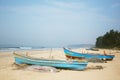 Goa seacoast with colorful boats, palm trees and sandy beach. Weather is windy, nobody is on the beach Royalty Free Stock Photo