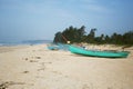 Goa seacoast with colorful boats, palm trees and sandy beach. Weather is windy, nobody is on the beach Royalty Free Stock Photo