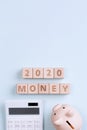 2020 goal, finance plan abstract design concept, wood blocks on blue table background with piggy bank and calculator, top view, Royalty Free Stock Photo