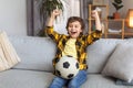 Goal. Happy little boy sport supporter watching match on tv with soccer ball and celebrating victory at home, free space