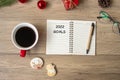 2022 GOAL with notebook, black coffee cup, Christmas cookies and pen on wood table. Xmas, Happy New Year, Resolution, To do list,