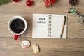 2024 GOAL with notebook, black coffee cup, Christmas cookies and pen on wood table. Xmas, Happy New Year, Resolution, To do list, Royalty Free Stock Photo