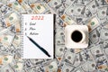 2022, GOAL, PLAN and ACTION. Notepad, pen and a cup of black coffee isolated on money background. Notepad with copy Royalty Free Stock Photo