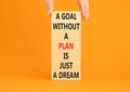 Goal and plan symbol. Concept words A goal without a plan is just a dream on wooden blocks. Beautiful orange background copy space