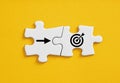 Goal target and arrow symbols connected on jigsaw puzzle pieces Royalty Free Stock Photo