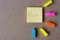 Goal word on notepad with multicolored sticky note on cork background