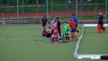 Goalie and field hockey players on a field with artificial turf, real photo