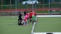 Goalie and field hockey players on a field with artificial turf, real photo