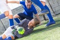 Goalkeeper catches ball in the penalty area. Young teen soccer game Royalty Free Stock Photo