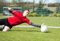 Goalkeeper in red saving a goal during a game