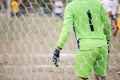 Goalkeeper stands against goal with net and stadium. Football gate net. Behind goal of soccer field Royalty Free Stock Photo