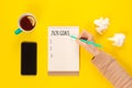 2020 goals banner. Notebook, pencil and cup of tea on a yellow background near crumpled sheet of paper and mobile phone Royalty Free Stock Photo