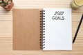 2022 GOALS on blank notebook, tree, pencil and candle on wood table. copy space for text.