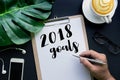 2018 goals concepts with hand writing on notepaper and business accessories