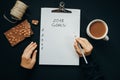 2018 goals list with woman hands, pencil, chocolate, cocoa, cone