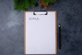 Goals for new year. Blank paper with goals title and black pencil on grey table. Flat lay. Top view. New year concept Royalty Free Stock Photo