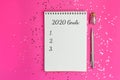 Goals for New Year 2020. Christmas, mockup for your design. notebook and pen on pink background, flat lay style. Silver sparkles Royalty Free Stock Photo