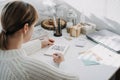 2022 goals, New year resolution. Woman in white sweater writing Text 2022 goals in open notepad on the table. Start new Royalty Free Stock Photo