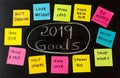 2019 Goals or New Year resolutions chalk handwriting and colorful post its memo notes on blackboard