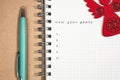 goals, Notebook and green pen with wooden red angel Royalty Free Stock Photo