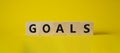 Goals symbol. Concept word Goals on wooden cubes. Beautiful yellow background. Business and Goals concept. Copy space Royalty Free Stock Photo