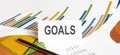 GOALS text on paper on chart background with pen