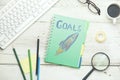 Goals text with racket on notepad and keyboard on table