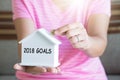 2018 goals with women hand putting money coin in piggy bank, Saving money concept, concept of financial savings to buy a house, G Royalty Free Stock Photo