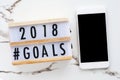 2018 goals on wood box and smart phone with blank on screen at o