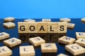 Goals word made of wooden letters on a mirror surface on a blue background Royalty Free Stock Photo