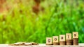 Goals word on stack of coins and a pile of golden coins on wooden table.