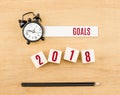 Goals 2018 year red on wood cube with pencil and clock top view