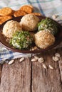 Goat Cheese balls with crackers, herbs and pumpkin seeds close-up. Vertical