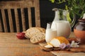 Goat cheese with condiments, bread and jug of milk on wooden tab Royalty Free Stock Photo