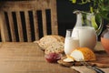 Goat cheese with condiments, bread and jug of milk on wooden tab Royalty Free Stock Photo