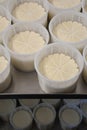 Goat cheeses in their molds at various heights.