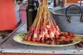 Goat, chicken, pork and fish meat stuck on a stick on a plate with marinade ready for grilling. Traditional Indonesian dish