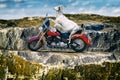 Goat on a motorcycle on a mountain road on the coast Royalty Free Stock Photo