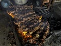 Goat satay on red fire grilling by people. traditional Indonesian food made from mutton