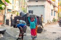 Asian construction worker carrying black stone to the asphalt mixer