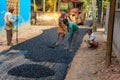 Male workers build road with asphalt