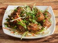 Gobi Manchurian, Popular indo-chinese food made of cauliflower florets, served in a white plate over a rustic wooden table. Royalty Free Stock Photo