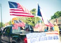 God bless the USA banner rear modern pickup truck dense of American flag on cargo bed driving on residential street smalltown Royalty Free Stock Photo