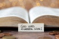 God loves a cheerful giver, handwritten text note in front of open holy bible book and golden coin money with bokeh background Royalty Free Stock Photo