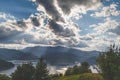 God rays above a lake at the foot of a mountain and clouds on the sky