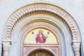 God's image mosaic above the doorway of a church.