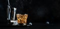 Godfather alcoholic cocktail with scotch whiskey, amaretto liqueur and ice. Black bar counter background, steel bar tools, copy Royalty Free Stock Photo