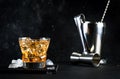 Godfather alcoholic cocktail with scotch whiskey, amaretto liqueur and ice. Black bar counter background, steel bar tools, copy Royalty Free Stock Photo